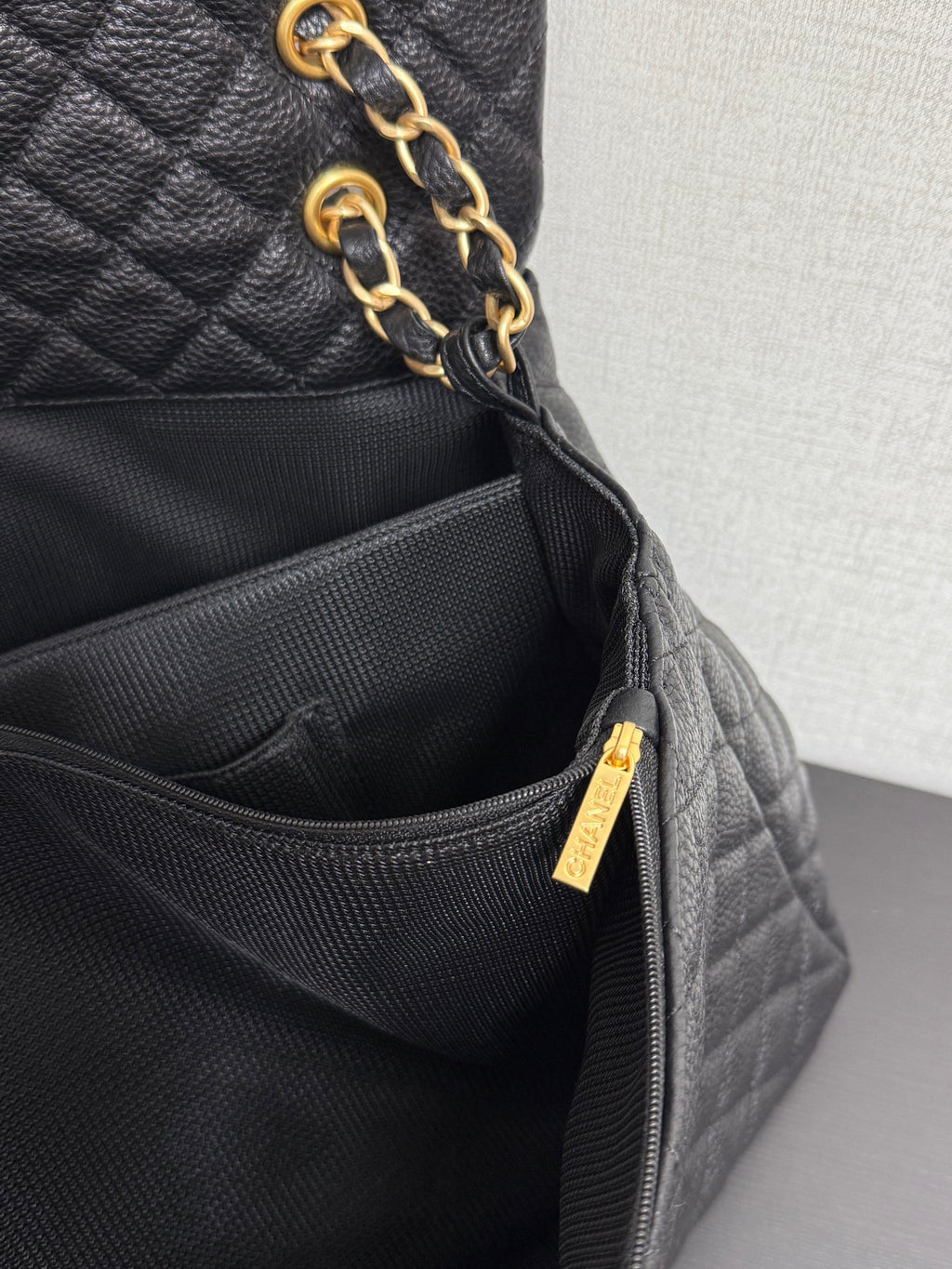 Black Chanel bag with gold zipper pull and interior zip pocket