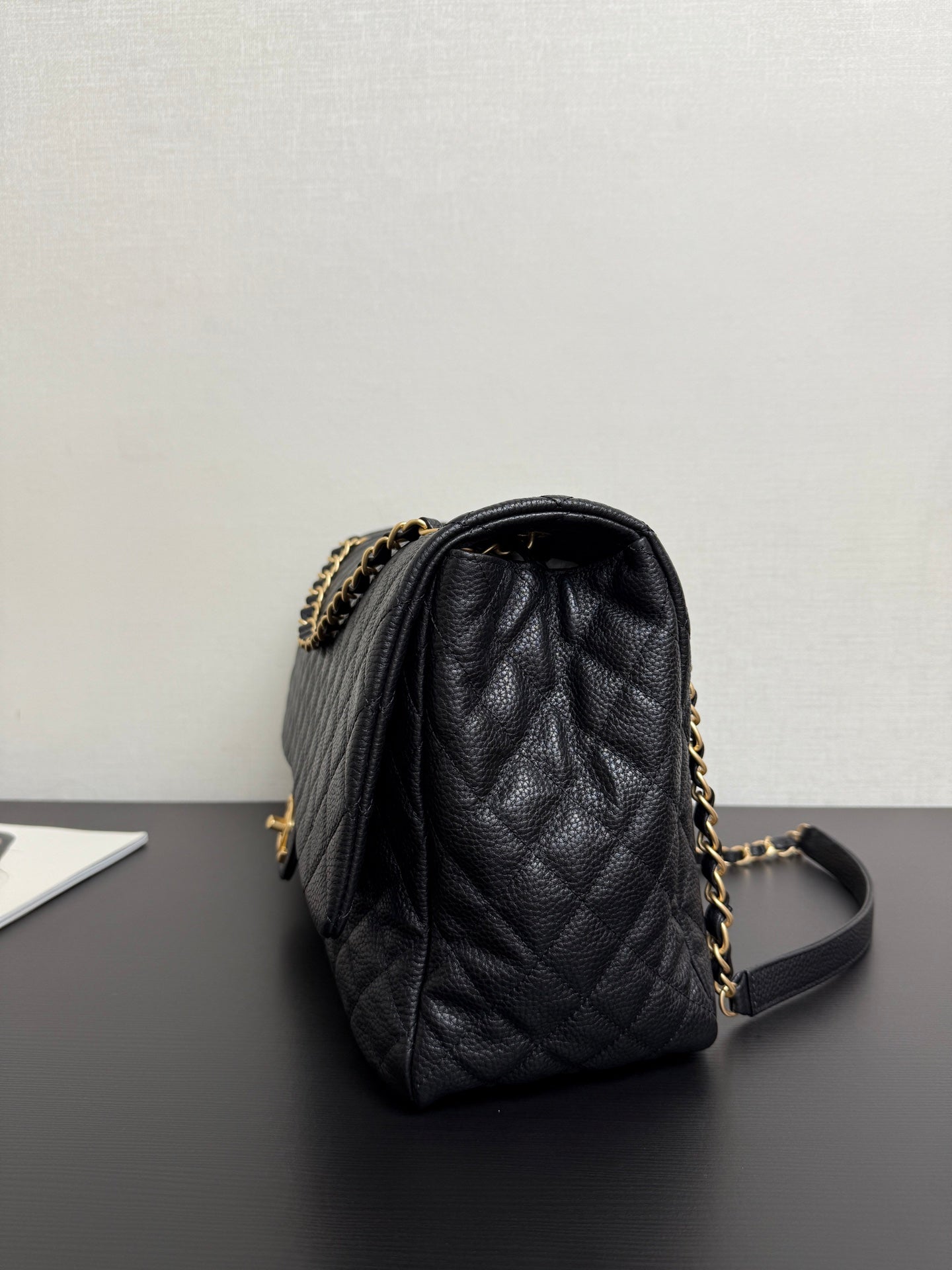 Black quilted Chanel bag with gold chain strap and leather top handle