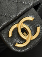 Gold-tone Chanel CC logo on black leather bag