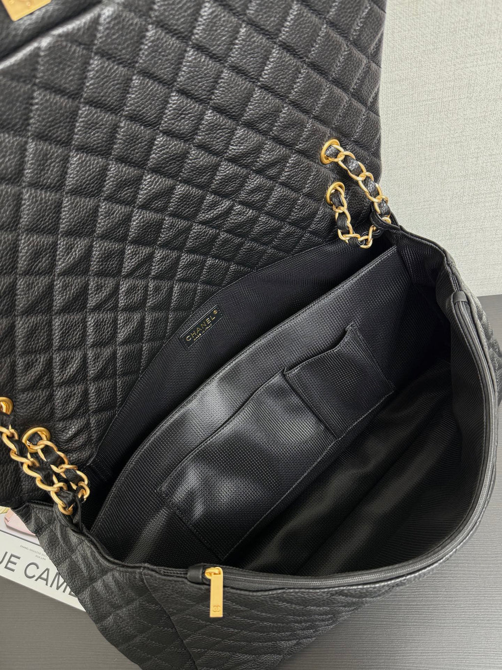 Black quilted Chanel bag interior with fabric lining and zip pocket