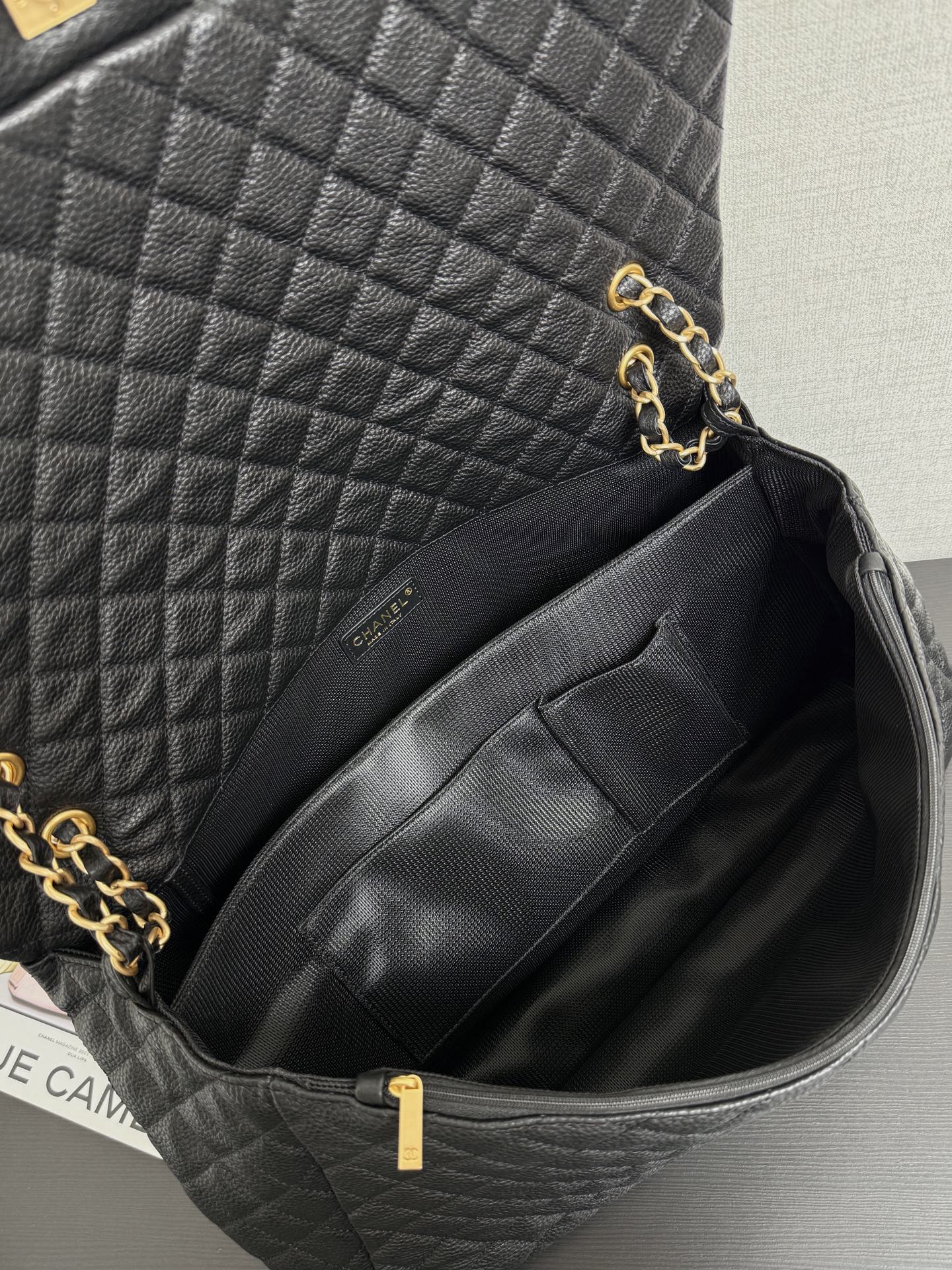 Black quilted Chanel bag interior with fabric lining and zip pocket