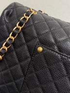 Black quilted Chanel flap with gold chain detail and small CC pin