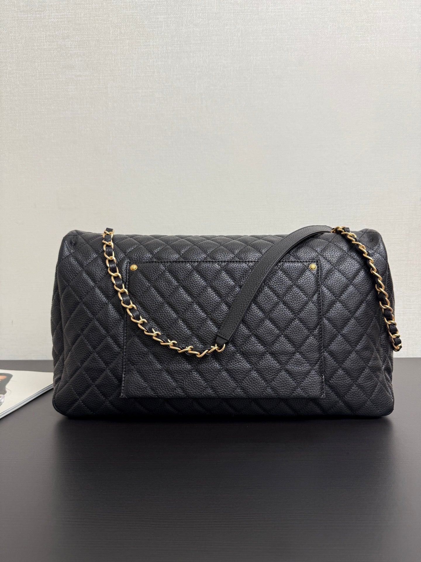 Quilted black Chanel bag with gold chain shoulder strap and CC logo front