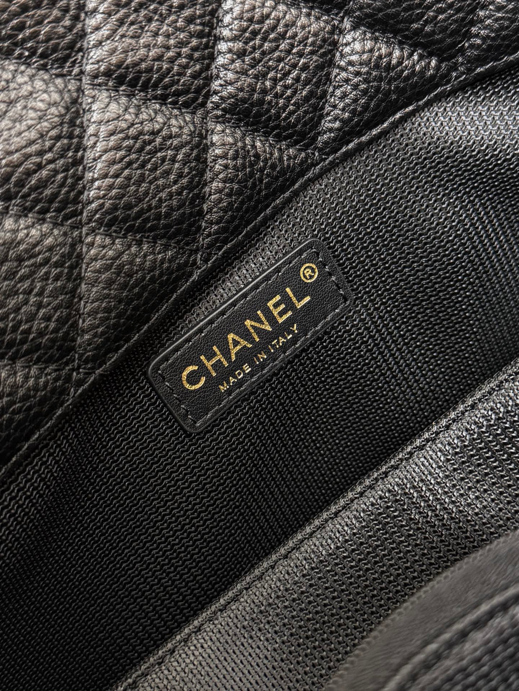 Black Chanel bag brand patch on quilted leather flap