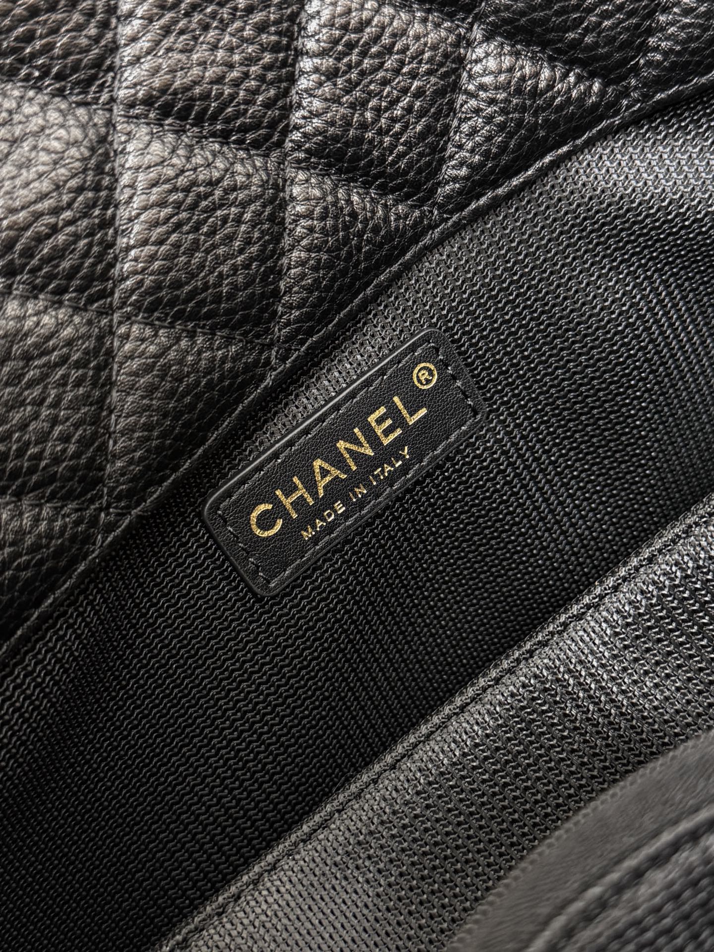 Black Chanel bag brand patch on quilted leather flap