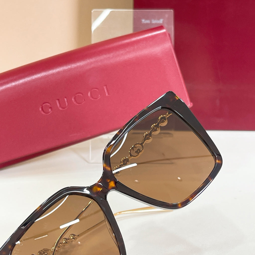 Gucci sunglasses with black square frames and tan-brown tinted lenses