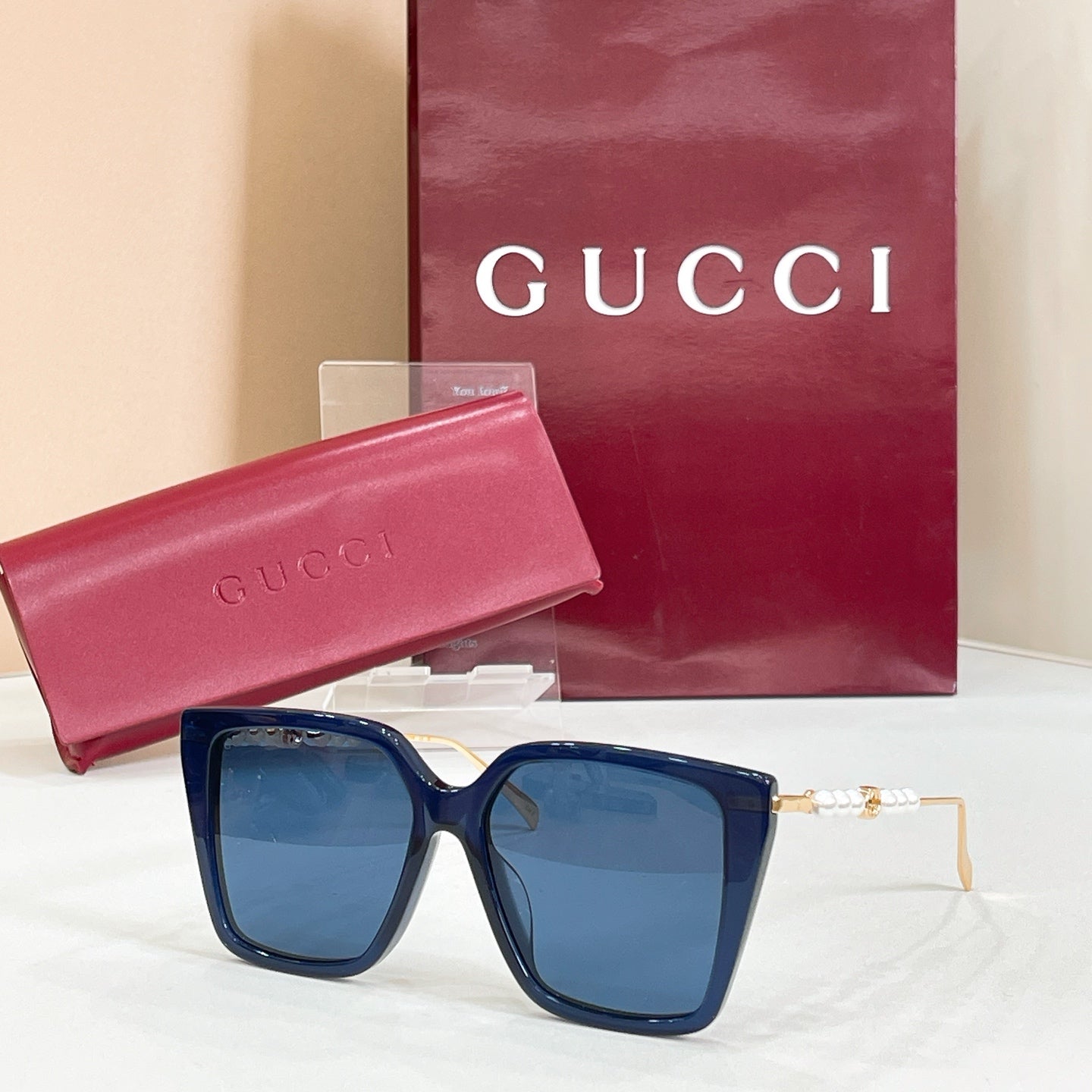 Gucci sunglasses with dark blue square frames and blue tinted lenses