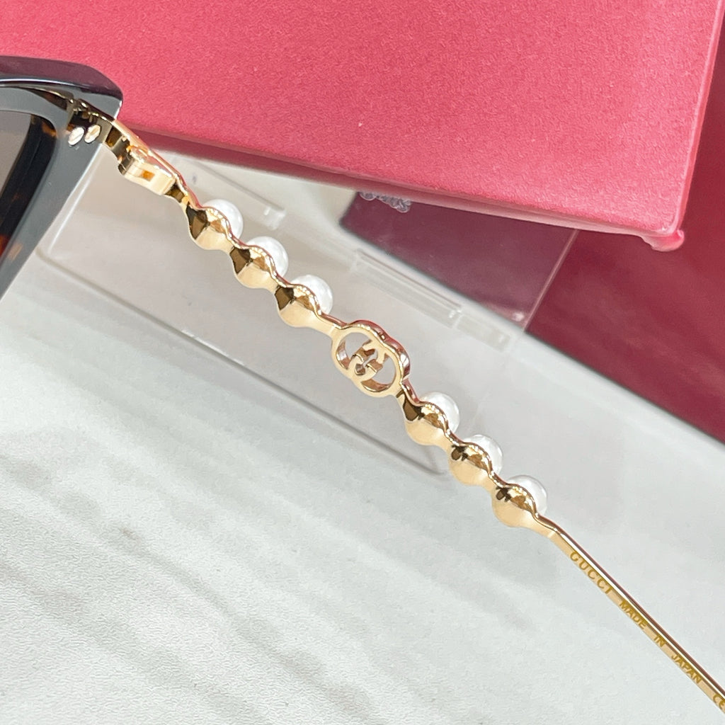 Gucci sunglasses temple detail with gold chain link and pearl accents