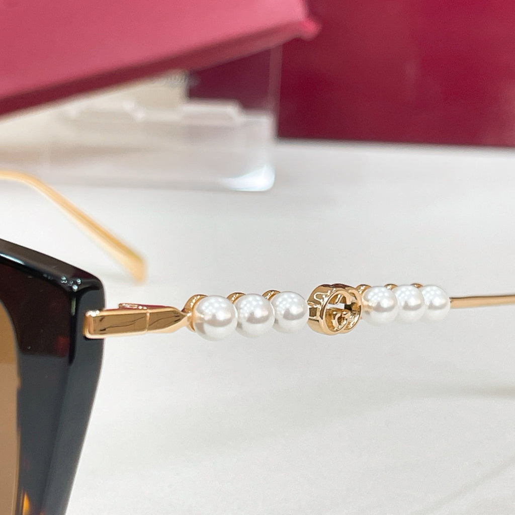 Gucci sunglasses temple detail with gold bar and pearl-bead accents