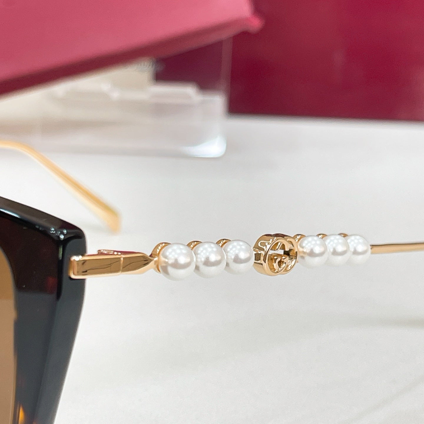 Gucci sunglasses temple detail with gold bar and pearl-bead accents
