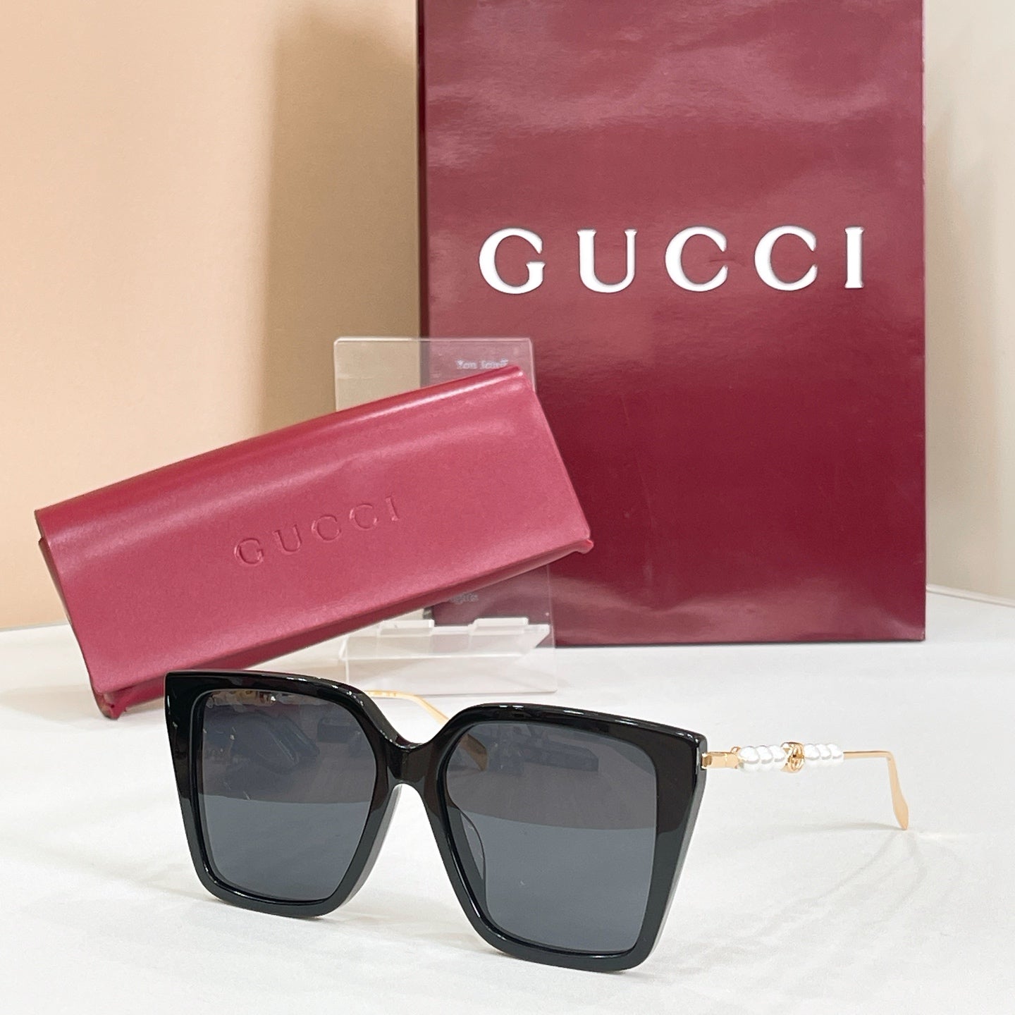 Gucci sunglasses with black square frames and dark blue tinted lenses