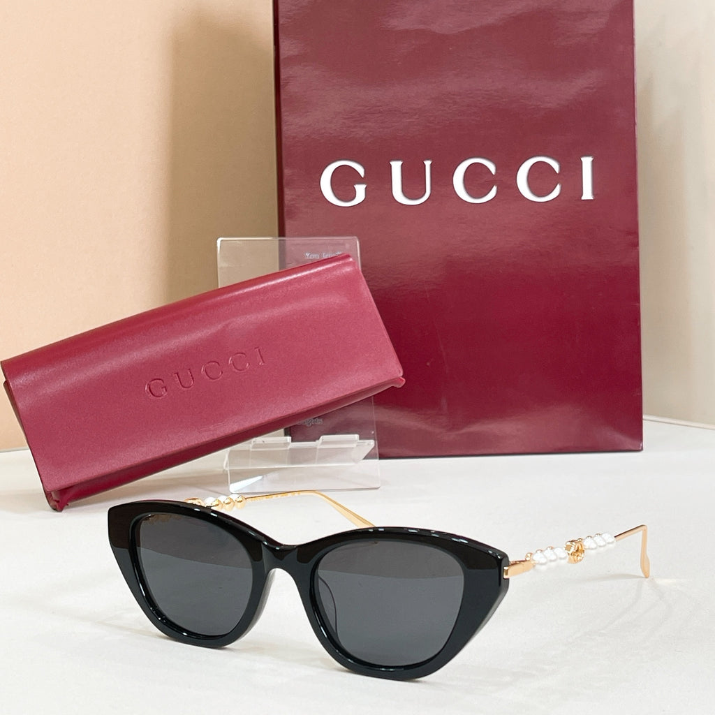 Sunglasses with black lenses and black frames, gold-tone temple details