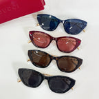 Set of four sunglasses with blue, maroon, brown, and black lenses and gold-tone accents