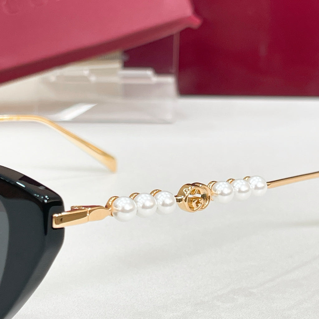 Sunglasses temple close-up with gold hardware and white pearl accents