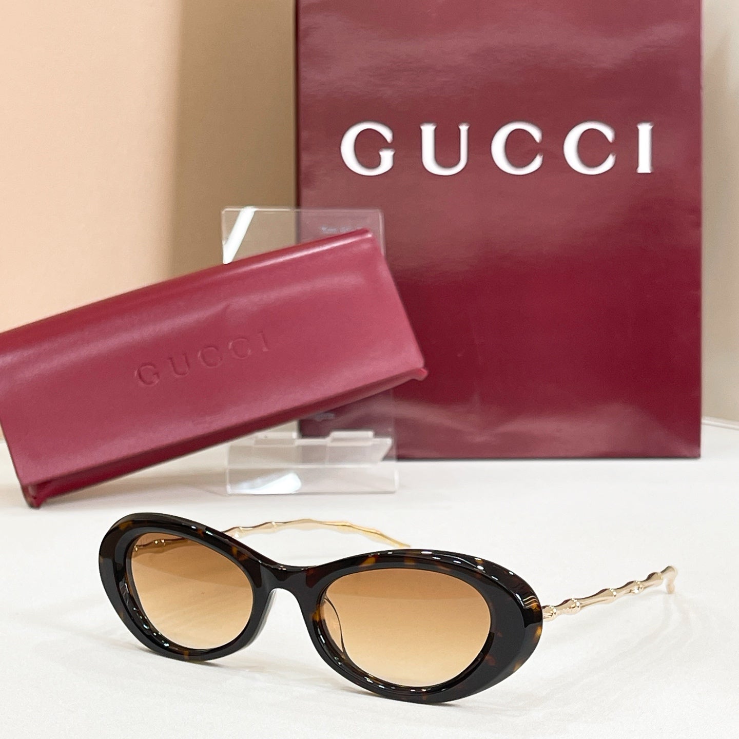 Gucci sunglasses, black round frames with warm brown tinted lenses and gold-tone arms