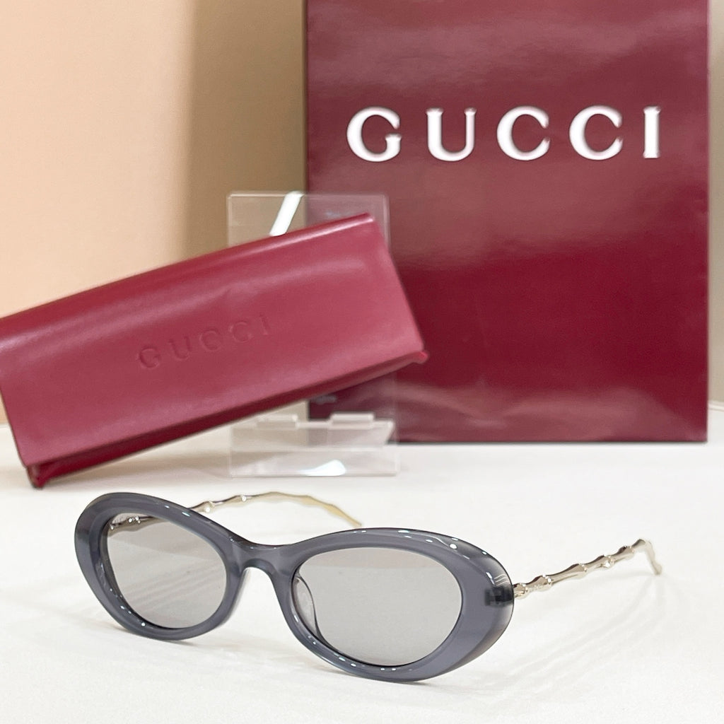 Gucci sunglasses, dark gray round frames with light gray lenses and gold-tone arms