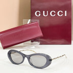 Gucci sunglasses, dark gray round frames with light gray lenses and gold-tone arms