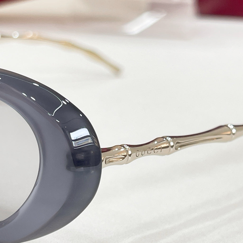 Gucci sunglasses, close-up: dark blue frame with gold-tone temple arms