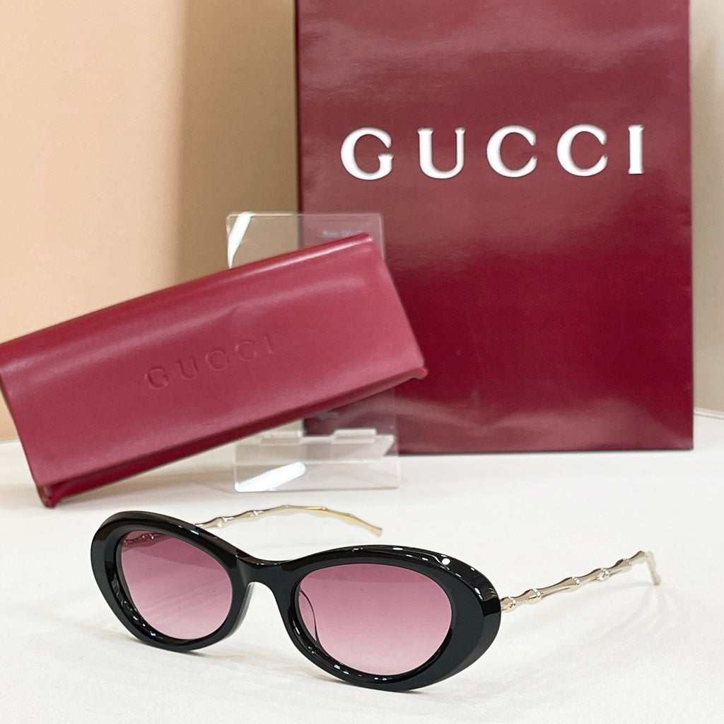 Gucci sunglasses, black round frames with pink tinted lenses and gold-tone arms