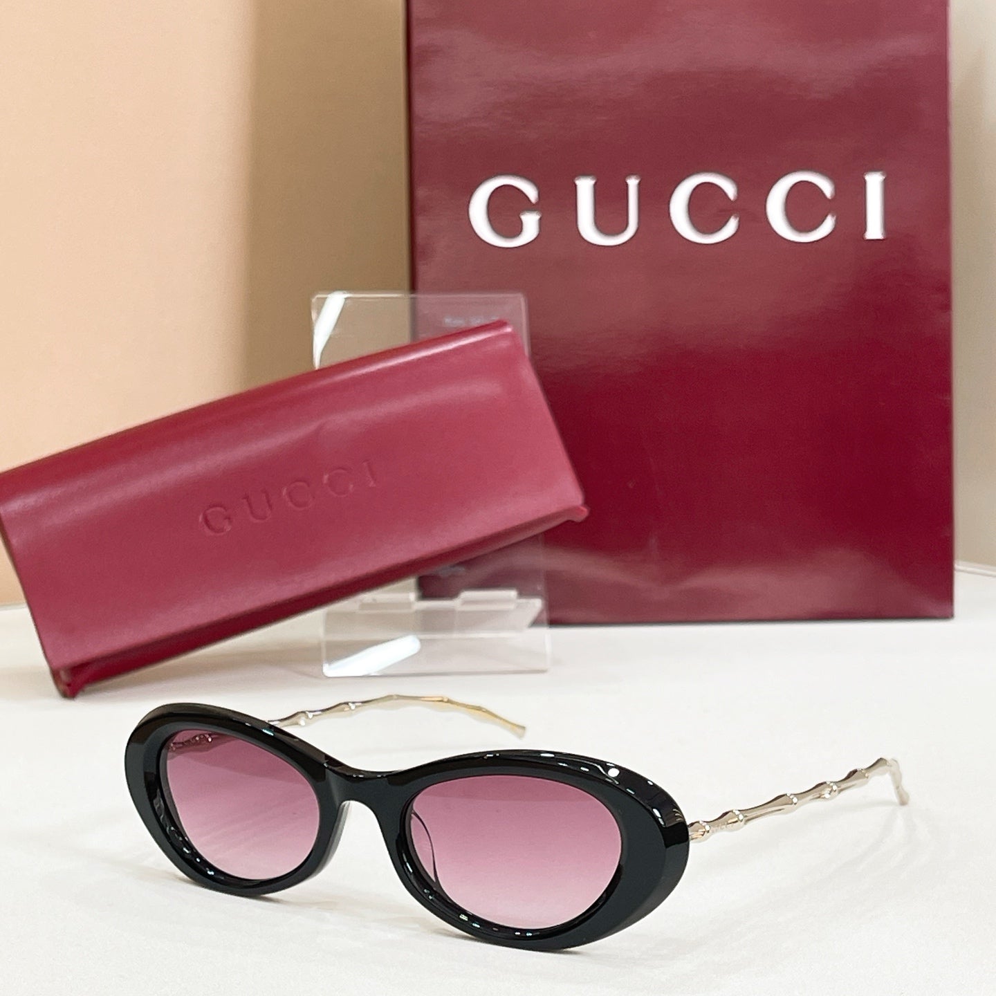 Gucci sunglasses, black round frames with pink tinted lenses and gold-tone arms