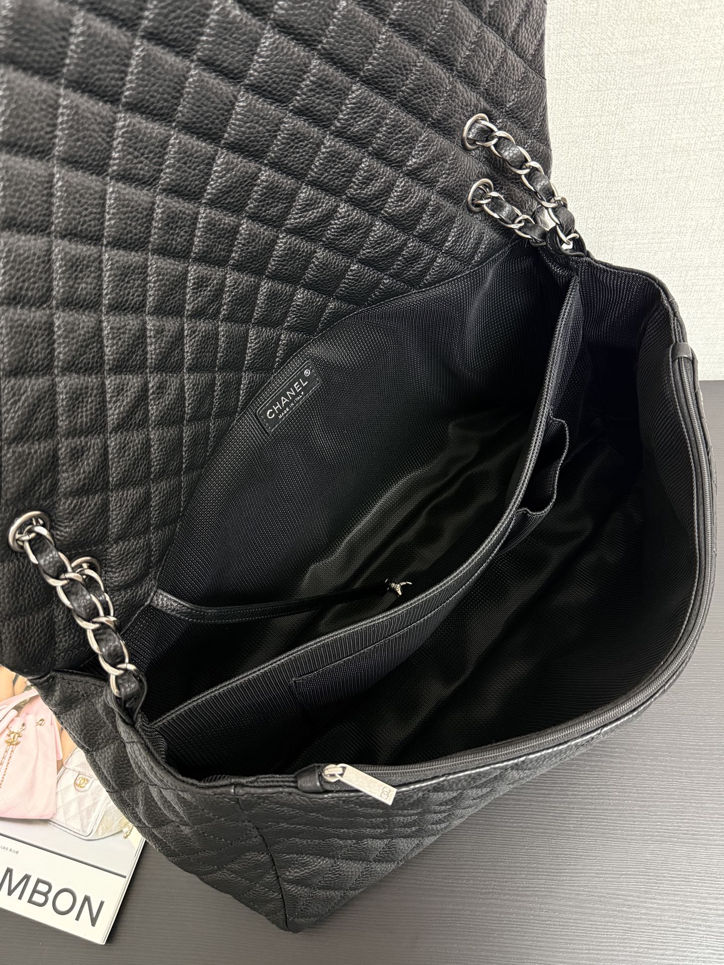 Chanel quilted shoulder bag interior with zipper trim and chain strap at top opening.
