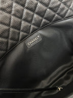 Chanel brand label inside dark quilted leather shoulder bag.