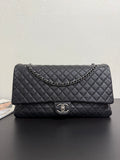 Chanel quilted flap bag in dark navy with chain strap and CC turn-lock clasp.