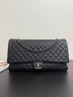 Chanel quilted flap bag in dark navy with chain strap and CC turn-lock clasp.