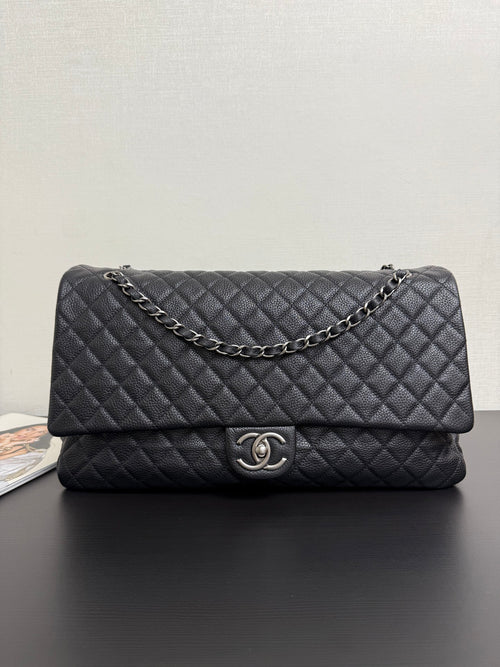 Chanel quilted flap bag in dark navy with chain strap and CC turn-lock clasp.