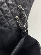 Chanel chain strap with silver-tone links on dark quilted leather bag.