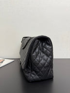 Chanel quilted shoulder bag side view in dark navy with chain strap and curved flap.
