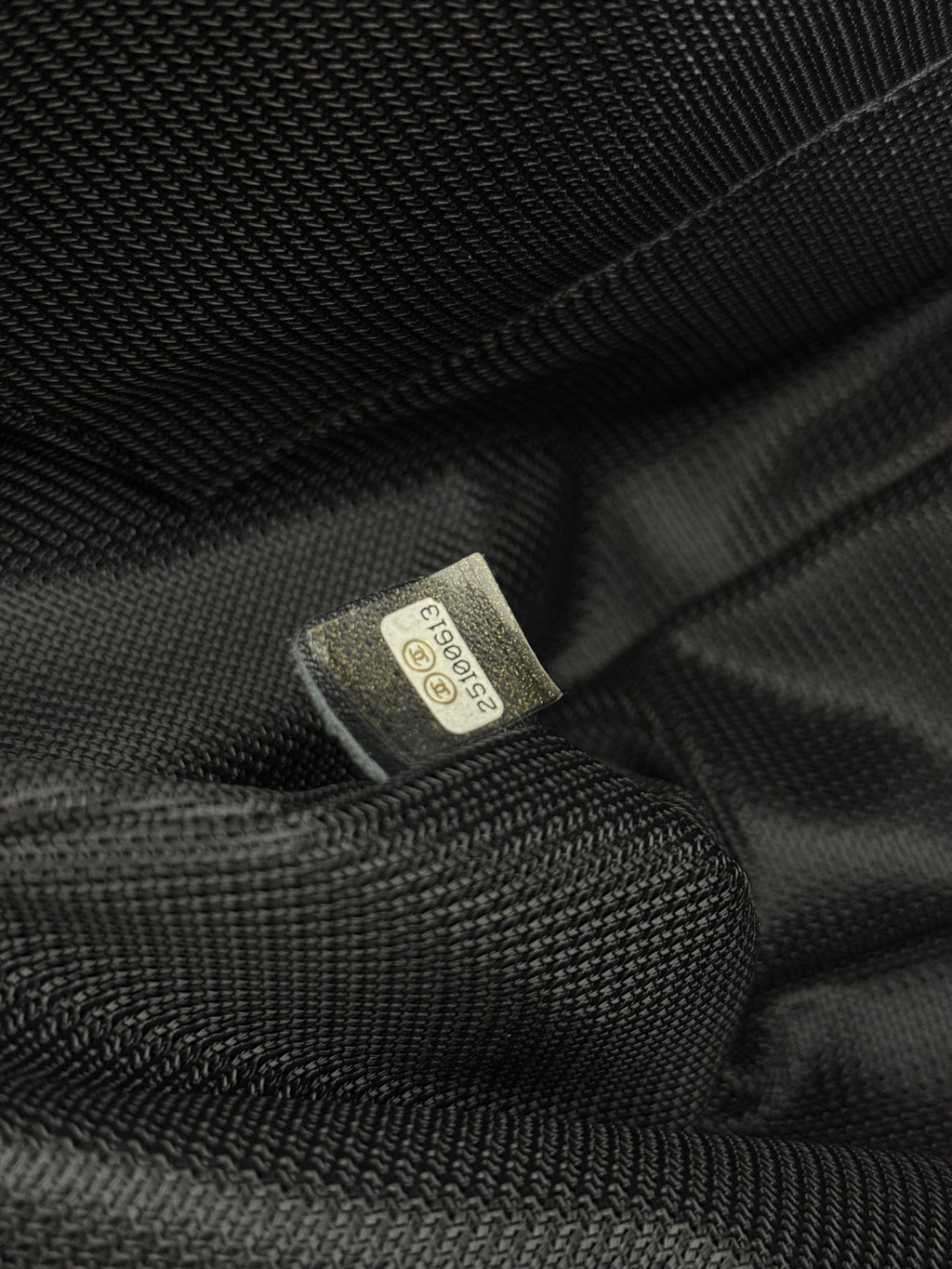 Textile care label inside dark lining of Chanel bag.