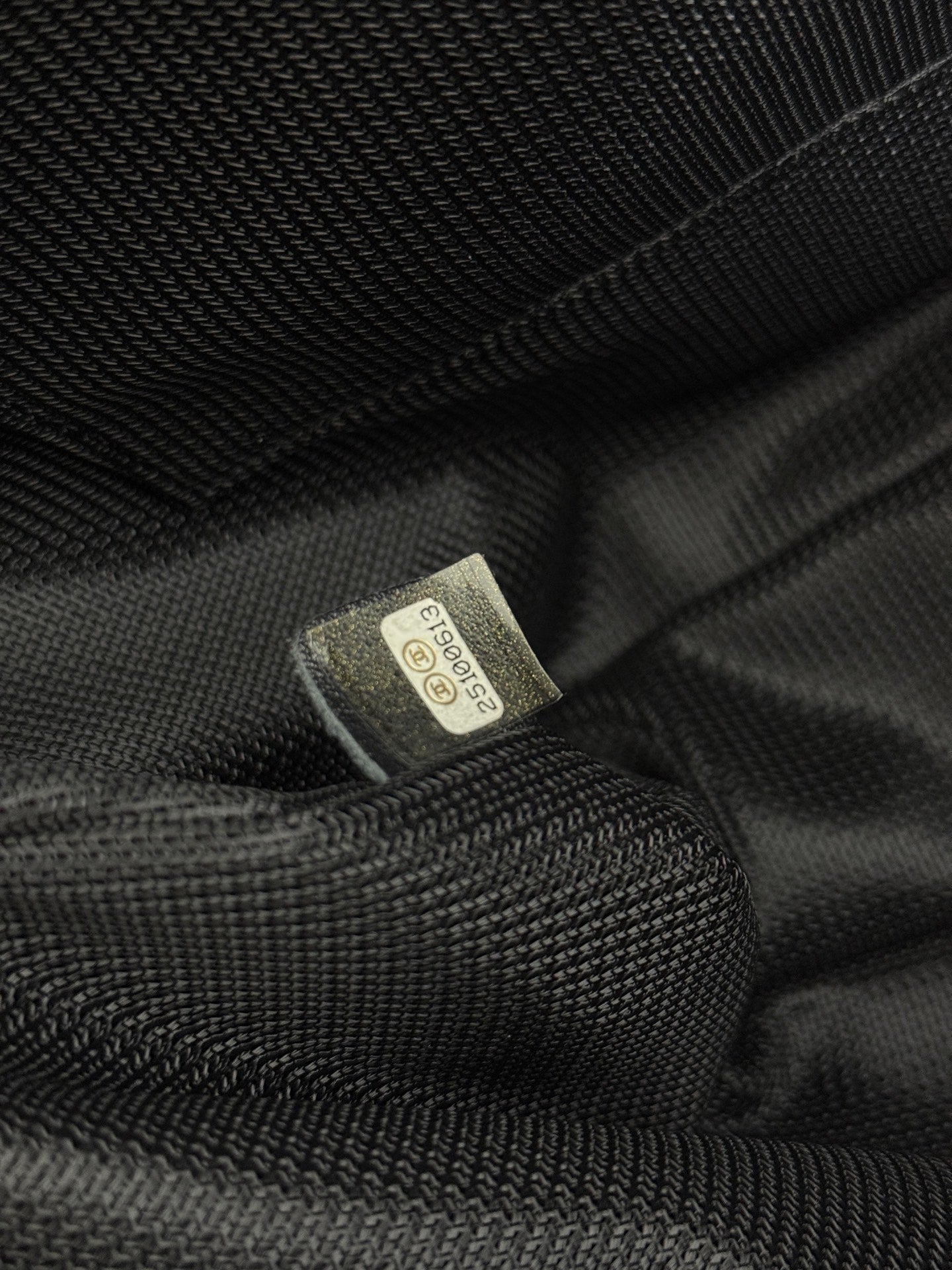 Textile care label inside dark lining of Chanel bag.