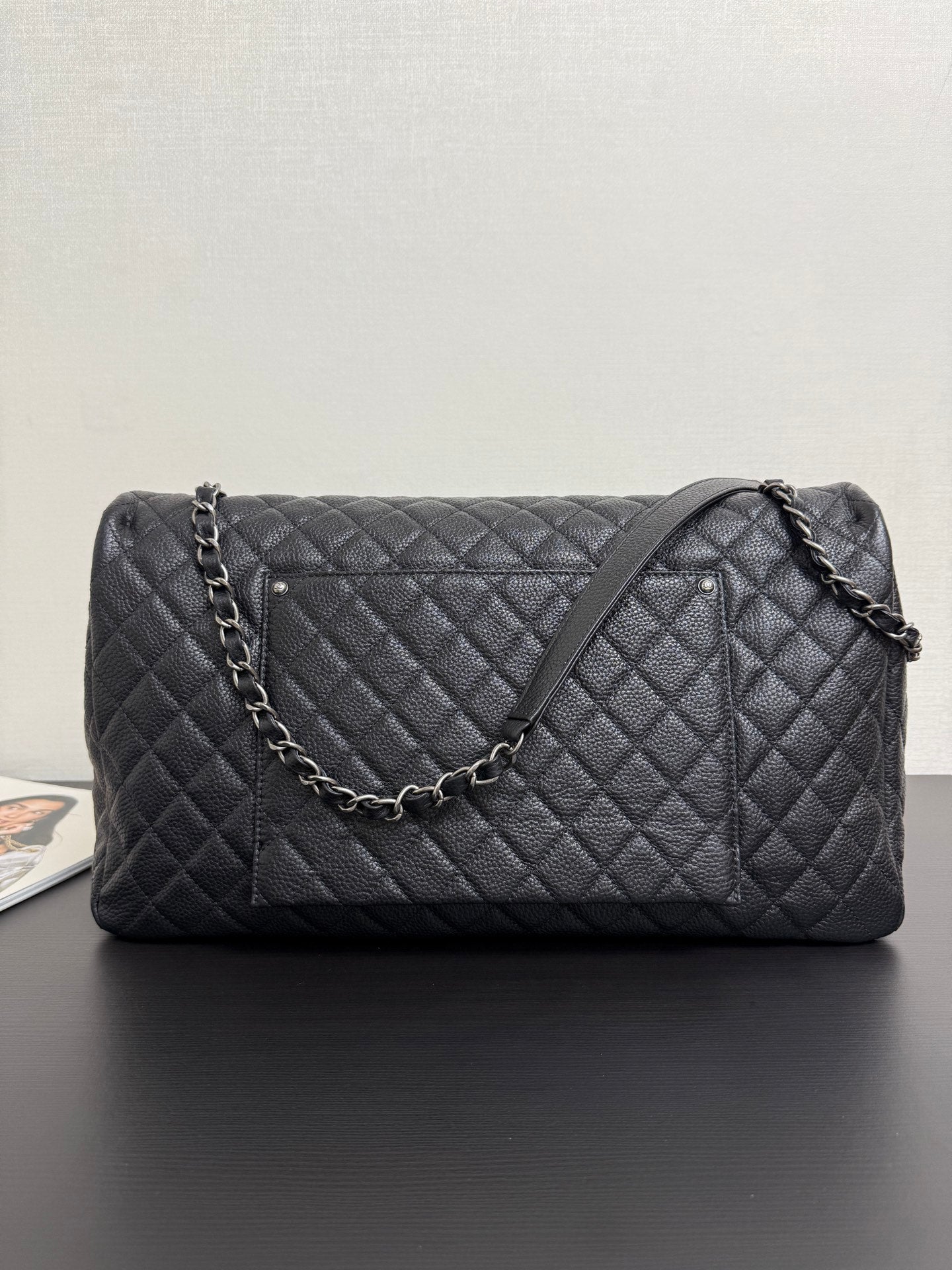 Chanel quilted shoulder bag in dark navy with chain strap and stitched diamond front panel.