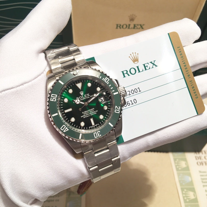 Rolex stainless steel watch with green bezel and black dial, held in white gloves