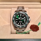 Rolex stainless steel watch with green bezel and black dial in a presentation box