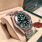 Rolex stainless steel watch with green bezel and black dial in display box