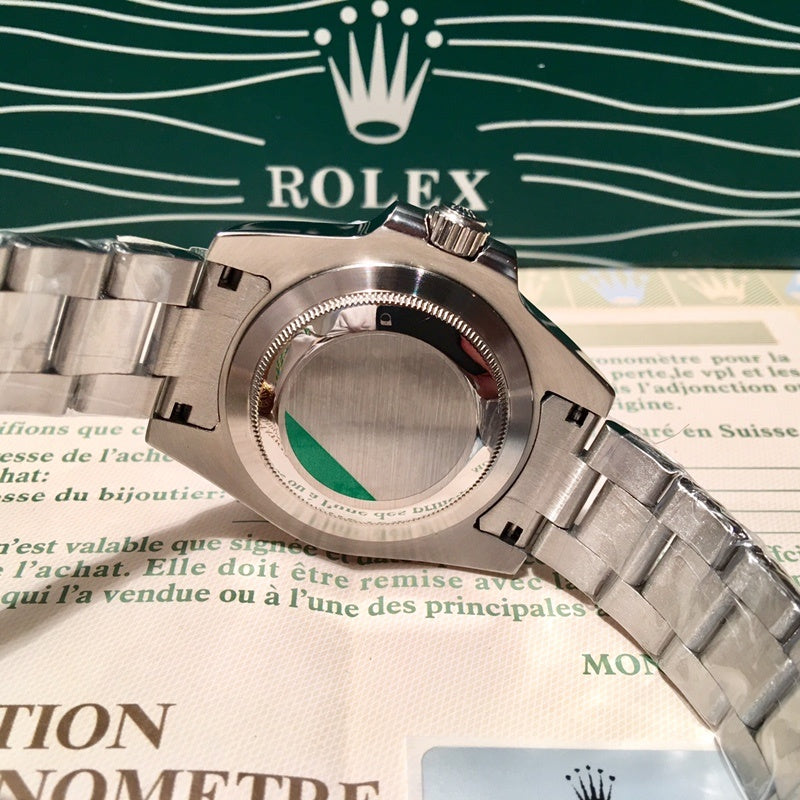 Rolex stainless steel watch case close-up with green accent ring on bezel