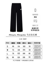 Dark wide-leg trousers with elastic waistband and side label