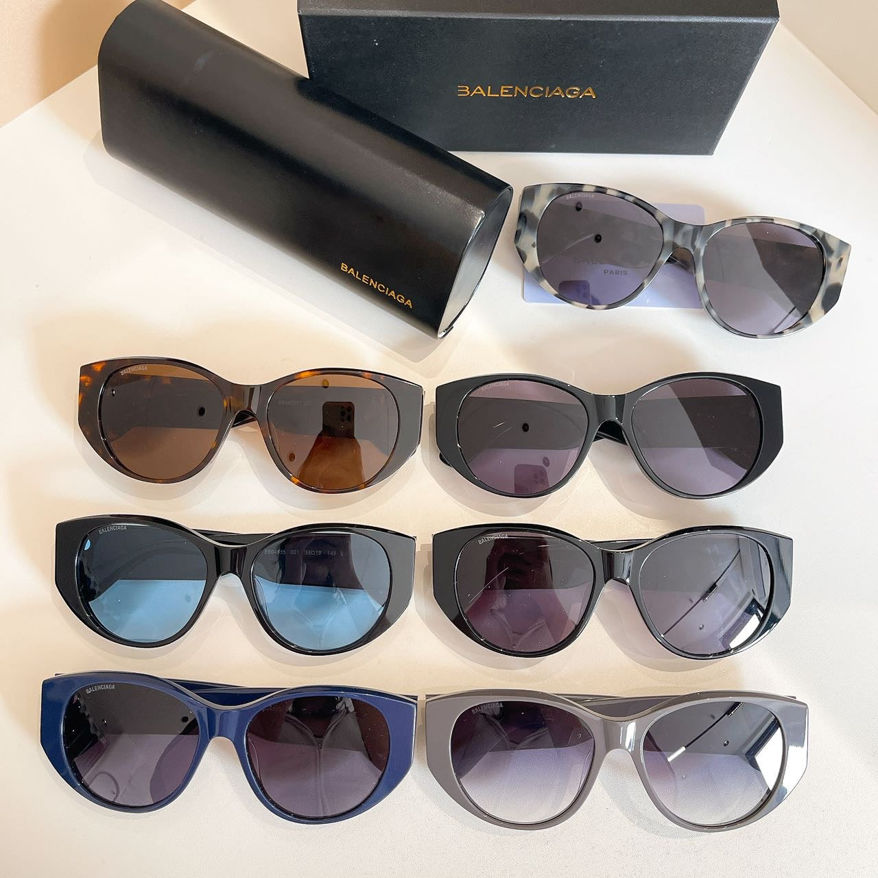 Assorted sunglasses with mixed colored frames and lenses, with black case