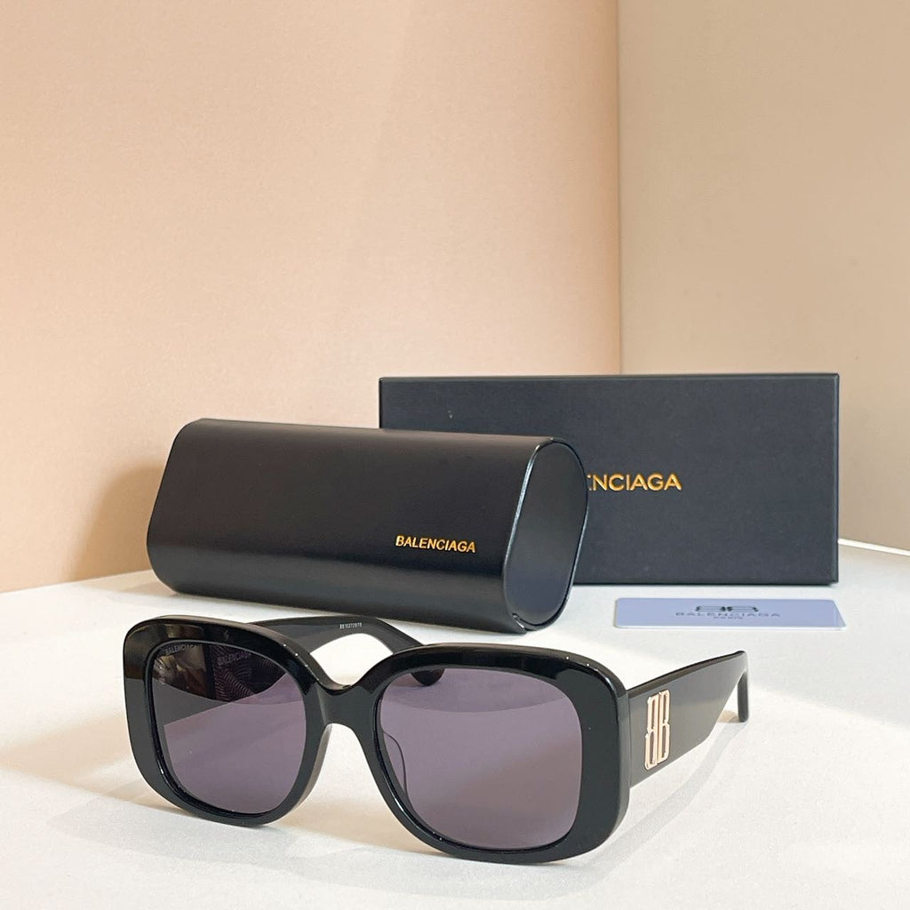Black sunglasses with oversized rounded frames and dark purple tinted lenses, logo on temple