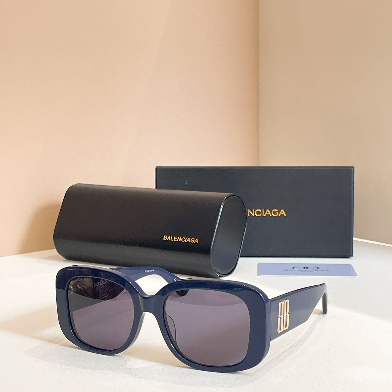Navy sunglasses with oversized rounded frames and purple tinted lenses, logo on temple