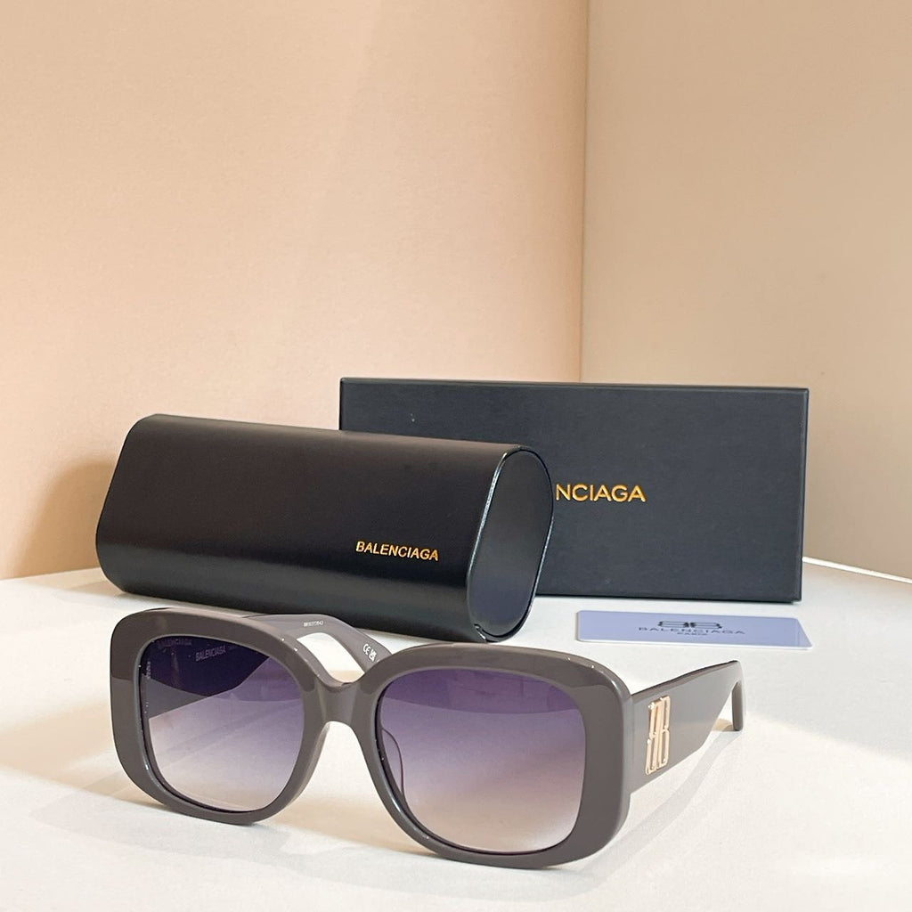 Gray sunglasses with oversized rounded frames and light purple tinted lenses, logo on temple