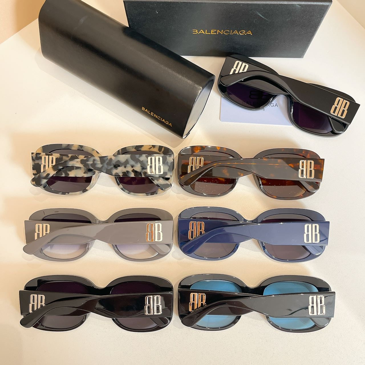 Assorted oversized sunglasses with HB logo on temples and tinted lenses, shown in rows