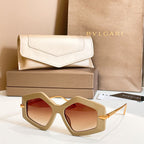 Octagonal sunglasses with beige frames and red-tinted lenses, gold-tone temples.