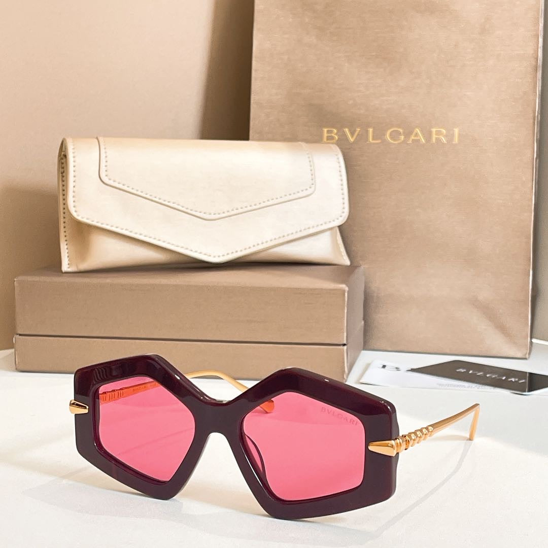 Octagonal sunglasses with dark frames and pink-tinted lenses, gold-tone temples.