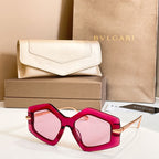 Octagonal sunglasses with red frames and pink-tinted lenses, gold-tone temples.