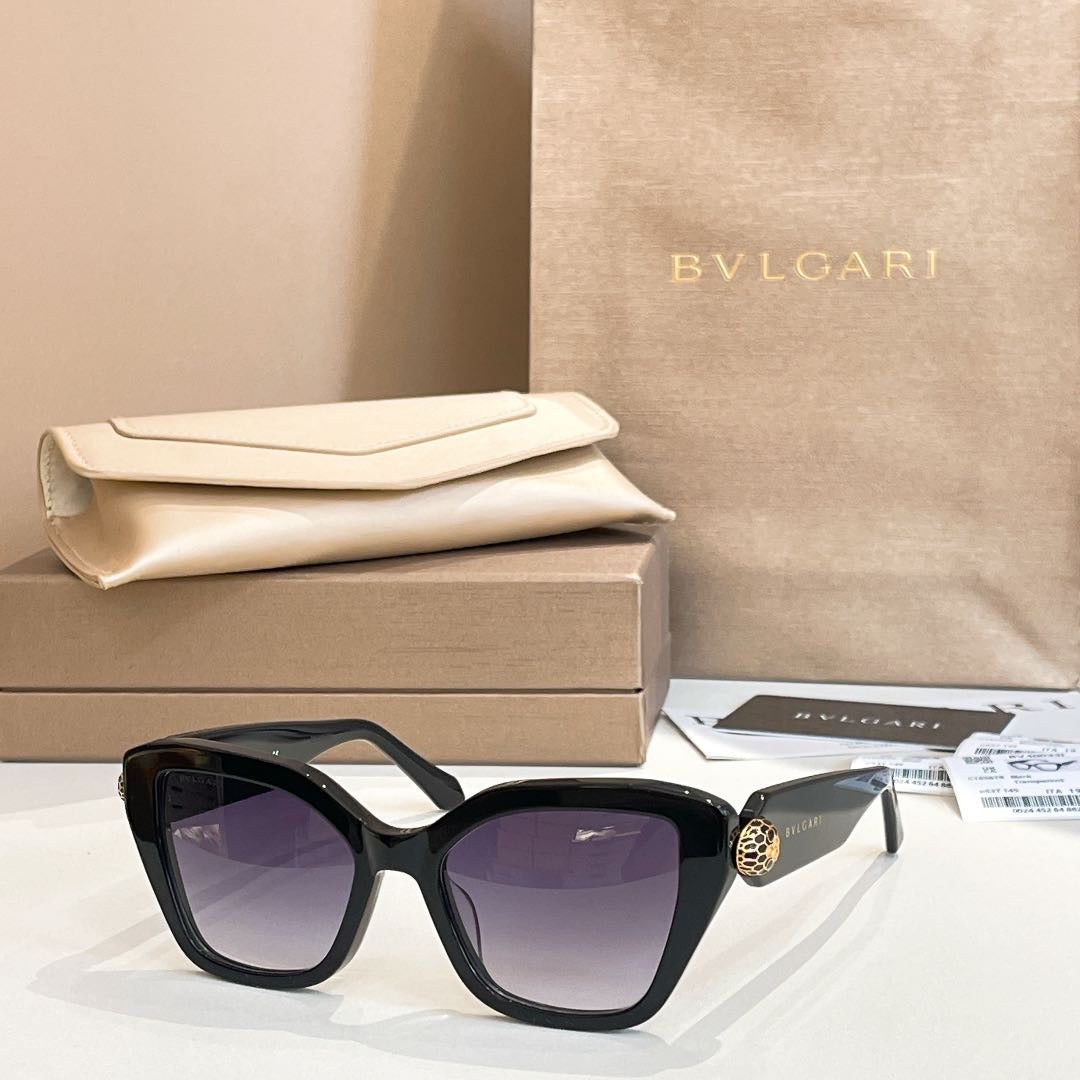 Black square glasses with dark lenses and gold-tone accent on the temple.
