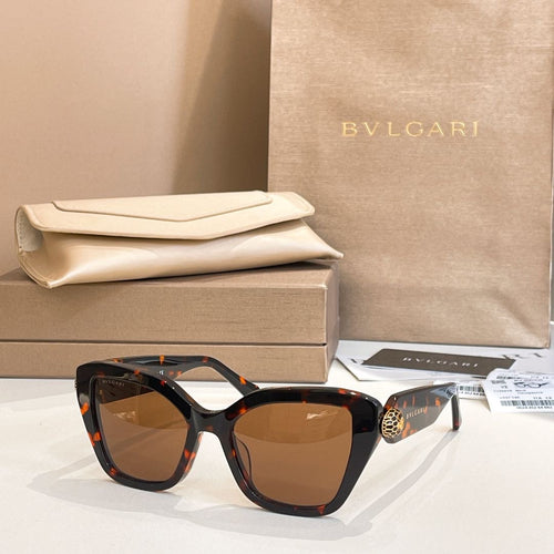 Black square eyeglasses with brown-tinted lenses and gold-tone temple detail.