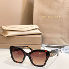 Tortoiseshell square glasses with dark lenses and gold-tone temple detail.